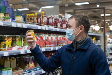 A man in a supermarket chooses food and drinks. Retail trade. Quarantine