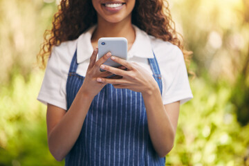 Young, waitress and phone for typing with smile for social media, joy for news story with online community. Black woman, mobile app and happiness for message with internet, post or like on website