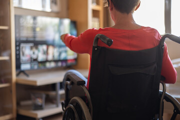 Home Entertainment For People With Physical Disabilities. Person With Disability In A Wheelchair Enjoying Streaming Services