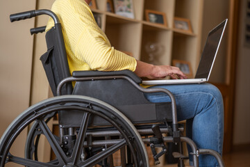 Fototapeta premium Disabled Person In A Wheelchair Teleworking From Home Using His Laptop, Checking Emails, Client Agenda, Projects Or Finances.