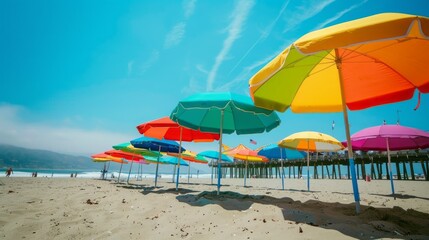 A beach scene with many colorful umbrellas on the sand