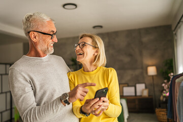 Mature couple husband and wife explore internet together on cellphone