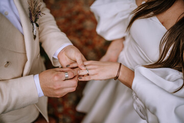 Riga, Latvia, - August 26, 2023 -  Close-up of groom placing a wedding ring on the bride's finger...