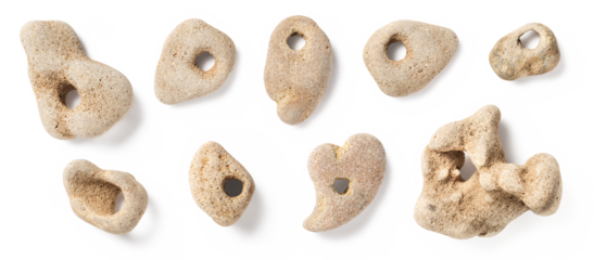 hag stones / hagstones, stones, rocks, or pebbles with natural holes, bright cream or beige colored sandstone, isolated over a transparent background, natural home decor, beach and vacation souvenirs 