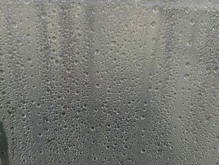 Texture of raindrops on glass. Natural backgrounds and textures with precipitation and moisture. Moisture is collected on the surface of the glass.