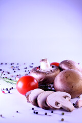 champignon mushrooms on a gray background with peppers and tomatoes. ingredients for a vegetarian dish