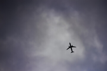 Lonely airplane in the sky against a gray sky background