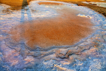 Subsidence funnels on salt marsh are filled with lakes of diverse colors. Red color caused by...