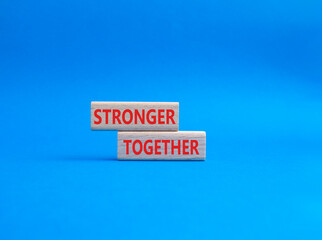 Stronger together symbol. Wooden blocks with words Stronger together. Beautiful blue background. Stronger together concept. Copy space.
