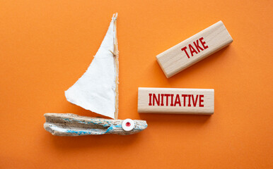 Take initiative symbol. Wooden blocks with words Take initiative. Beautiful orange background with...