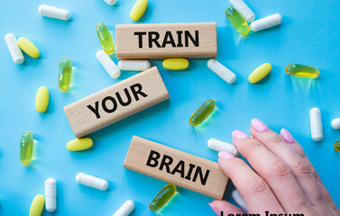 Train Your Brain symbol. Concept words Train Your Brain on wooden blocks. Beautiful blue background...