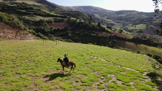 un joven y atractivo campesino montando un caballo caminando bajo la c&aacute;lida luz del sol durante el d&iacute;a. Concepto de viaje de estilo de vida saludable, turismo experiencial.rural,quechua,estilo de vida