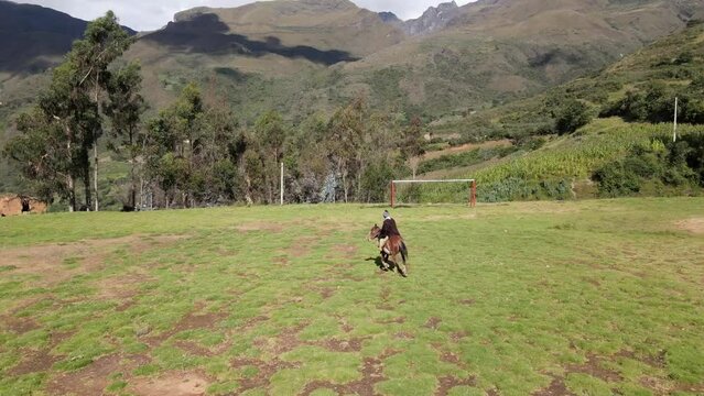 un joven y atractivo campesino montando un caballo caminando bajo la c&aacute;lida luz del sol durante el d&iacute;a. Concepto de viaje de estilo de vida saludable, turismo experiencial.rural,quechua,estilo de vida