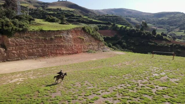 un joven y atractivo campesino montando un caballo caminando bajo la c&aacute;lida luz del sol durante el d&iacute;a. Concepto de viaje de estilo de vida saludable, turismo experiencial.rural,quechua,estilo de vida
