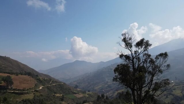 Mujer excursionista viajera, aventurera con mochila sinti&eacute;ndose victoriosa frente a la monta&ntilde;a, al aire libre para la educaci&oacute;n de la naturaleza en vacaciones. Concepto de viaje,casa quechua