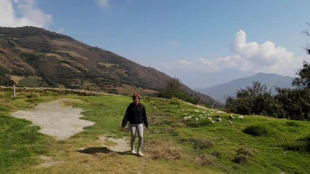 Mujer excursionista viajera caminando, aventurera con mochila sinti&eacute;ndose victoriosa frente a la monta&ntilde;a, al aire libre para la educaci&oacute;n de la naturaleza en vacaciones. Concepto de viaje,salto