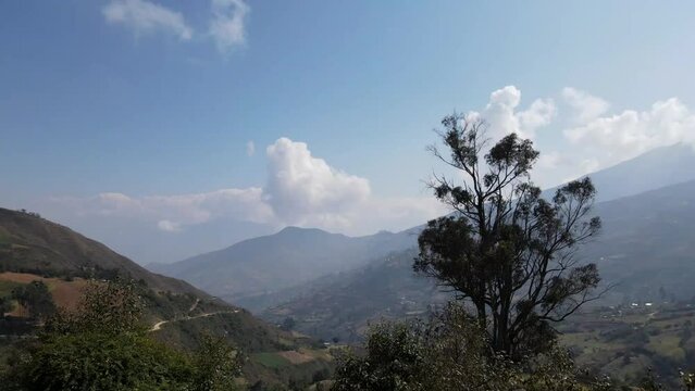Mujer excursionista viajera, aventurera con mochila sinti&eacute;ndose victoriosa frente a la monta&ntilde;a, al aire libre para la educaci&oacute;n de la naturaleza en vacaciones. Concepto de viaje,casa quechua