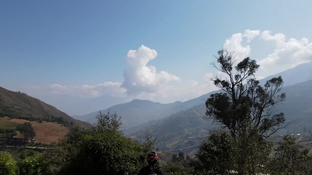 Mujer excursionista viajera, aventurera con mochila sinti&eacute;ndose victoriosa frente a la monta&ntilde;a, al aire libre para la educaci&oacute;n de la naturaleza en vacaciones. Concepto de viaje,casa quechua