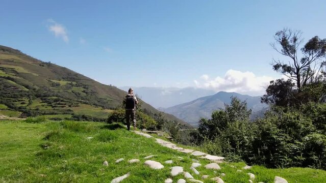 Hermosas monta&ntilde;as y hombre joven turista caminando con mochila en el camino en verano. Paisaje con turista en la cima de la monta&ntilde;a, bosque, colinas, cielo blancos con nubes, Viaje,quechua,sierra