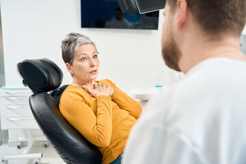 Scared woman sitting in dentist chair, visiting dental practitioner