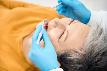 Dental hygienist undertaking patient examination using special dental tools