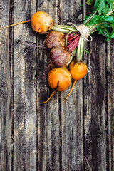 Colorful rainbow beets on the rustic wooden background. Golden, pink and purple beets on the open air.