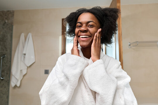 Portrait of young Black woman smiling at camera enjoying skincare in morning, copy space