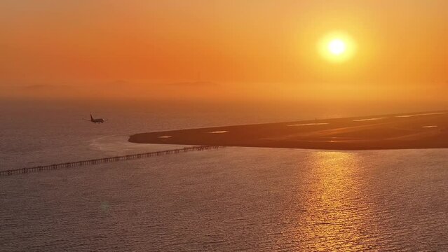 Aerial view of a plane landing at San Leandro Airport at sunset, USA