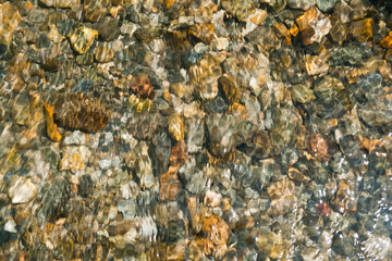 texture of peebles covered in a layer of clear flowing water