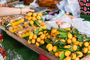 yellow Mariana plum fruits are collected in a bunch on a market counter. Buying fruit in Thailand