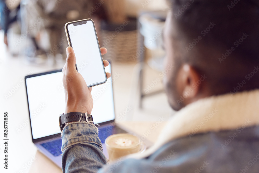 Poster man, back and smartphone or laptop screen in coffee shop, mock up and freelancer relax with tech or 