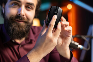 Close up shot of happy influencer endorsing wireless mouse from sponsor, rating it highly. Friendly media star advertising office computer peripheral from partnering brand to viewers on social media