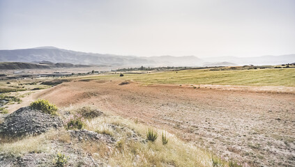 Fototapeta premium Spacious landscape view of mountains and hills with fields in Tajikistan, sunny summer day in nature