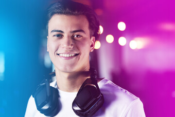 Portrait, headphones and happy gamer in neon lights, online streaming and competition for esports...