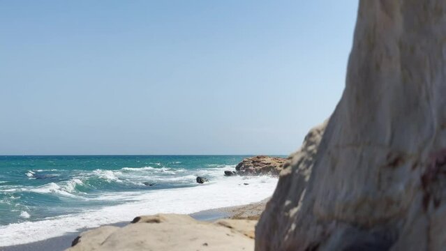 Wide-angle view of a scenic beach with a prominent rocky outcrop, blue sea, and clear sky. costa del sol, sotogrande, andalusia. playa de sardina
