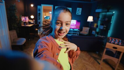 Small girl taking part in viral dance craze after seeing favorite celebrities doing it, filming POV style video. Little kid doing trendy dancing challenge, recording with selfie smartphone camera