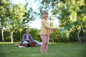 Fototapeta premium Mother and her daughter working together in garden
