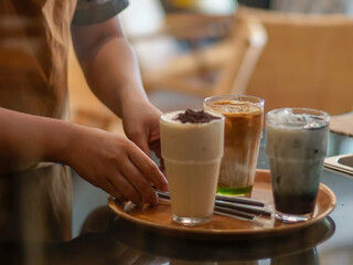 Waiter prepare to serve beverages on a wooden tray
