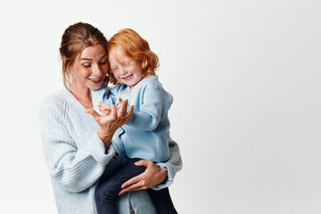 Happy mother and child in travel smiling family portrait in front of white background