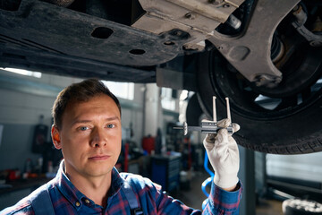 Male holding tool in the car service