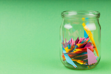 Glass Jar Filled with Colorful Paper Scraps, Reducing Paper Waste Concept, Copy Space