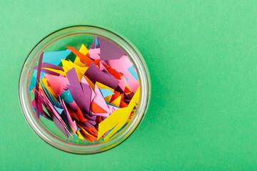 Glass Jar Filled with Colorful Paper Scraps, Reducing Paper Waste Concept, Copy Space