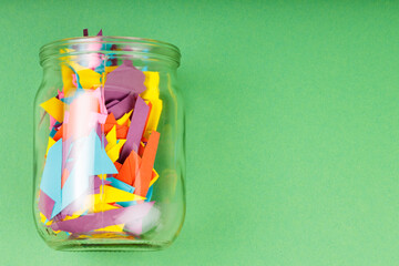 Obraz premium Glass Jar Filled with Colorful Paper Scraps, Reducing Paper Waste Concept, Copy Space