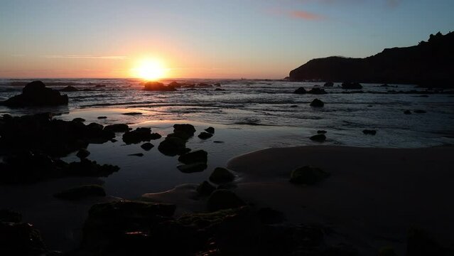Sole al tramonto su una spiaggia.