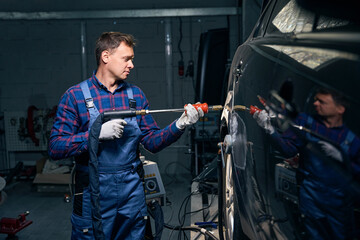 Worker working with front fender in tire fitting
