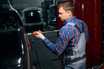Male working with front fender in tire fitting