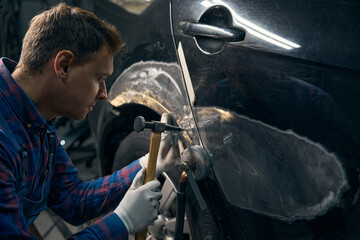 Skilled engineer working with front fender with instrument