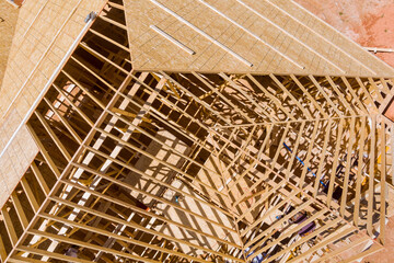 Under construction, are wooden beams framing roof wall of new home