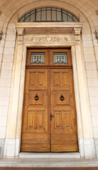 huge antique wooden double-leaf door with an ornated cornice 