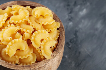 Uncooked Creste di Gallo Pasta on Dark Concrete Background, Copy Space
